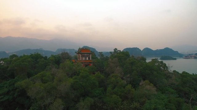 Chinese temple on top of  hill on background of lake