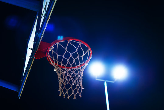 Basketball hoop on outdoor court at night