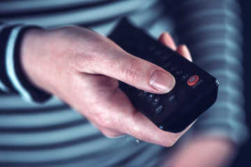 Female hand with television remote control