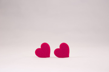 two red felt hearts on white