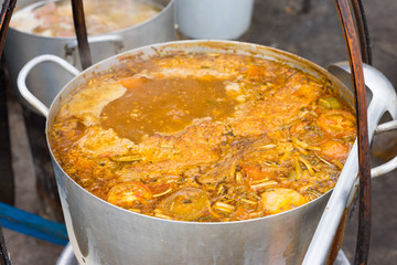 Large pot of Bun Rieu - Vietnamese meat rice vermicelli soup, is served with tomato broth and topped with crab or shrimp paste
