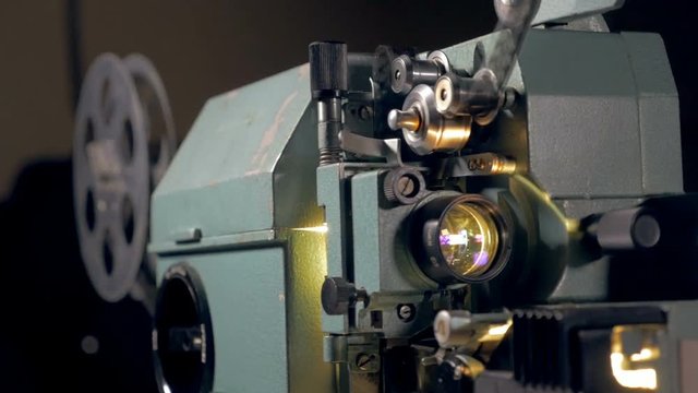 4K vintage film projector working in dark.