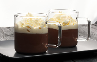 Hot chocolate cocoa with whipped cream on vintage wooden background, selective focus
