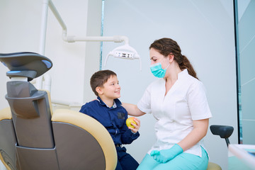 Fototapeta premium Doctor dentist and child handshake in the office. Dental treatment.