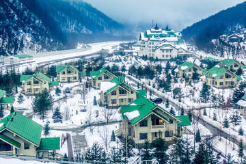 Fototapeta na wymiar Cozy houses in snowy mountains. Krasnaya Polyana, Sochi, Russia