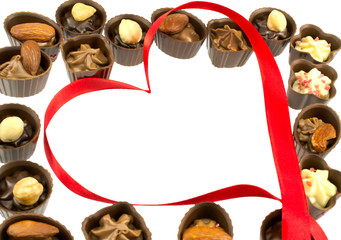 chocolates and red tape in the form of heart isolated on white b