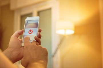 Smart Home: Man Controlling Lights With App On His Phone