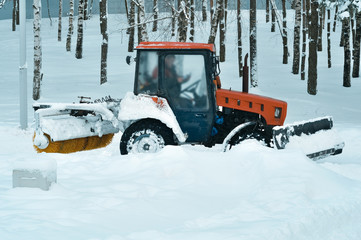 Fototapeta na wymiar Tractor clean snow in the park