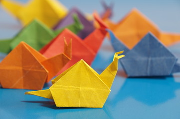 Paper origami snail isolated on a colorful background © romanklevets