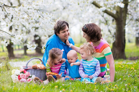 Family with children enjoying picnic in spring park