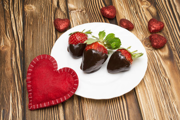 Fresh strawberries dipped in dark chocolate and heart on wooden background. Valentine's Day