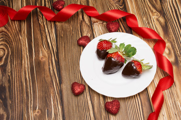 Fresh strawberries dipped in dark chocolate and heart on wooden background. Valentine's Day