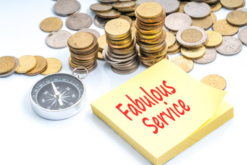 Coins, compass and text on sticky note with travel and financial concept