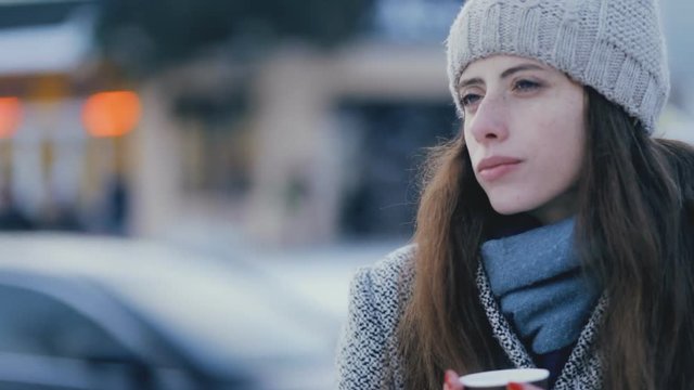 Young woman drinking hot tea in winter evening