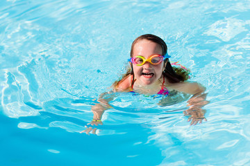 Child learning to swim in pool