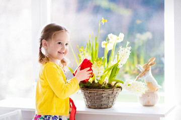 Little girl watering spring flowers