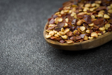 Dried Chili pepper in wood spoon on gray background