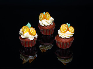 Terracotta cupcakes on black glass.