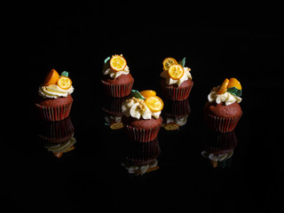 Terracotta cupcakes on black glass.