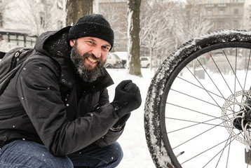 A man rides a bicycle in snowy weather