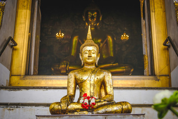 Public place Buddha statue with thai art architecture and Big buddha gold background in church at Wat Suthat temple. This is a Buddhist temple in Bangkok .