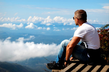 Man relaxes on the edge of the cliff . Plateau 