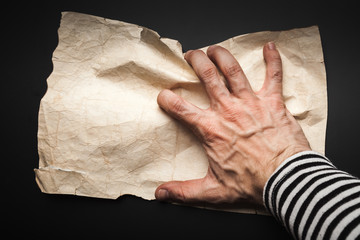 Hand catching empty old crumpled paper