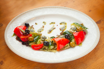 delicious greek salad on  plate on wooden background