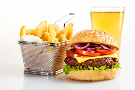 Tasty burger with basket of fries and beer