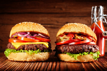 Two freshly made burgers with red sauce