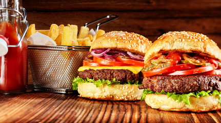 Two tasty burgers with basket of fries and sauce