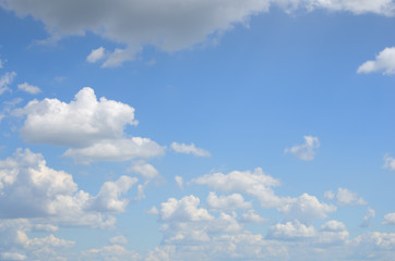 Naklejka na ściany i meble Blue sky with many of white and gray clouds above the water on summer day as a natural background for your text or picture; cloudscape running to horizon