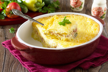 Casserole with potatoes, meat and cheese on a wooden table. Spac