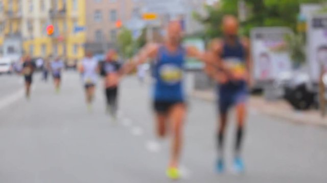 Blurred shot of people running on marathon on street