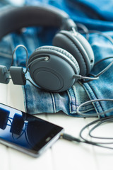 Obraz na płótnie Canvas Headphones, cellphone and blue jeans.