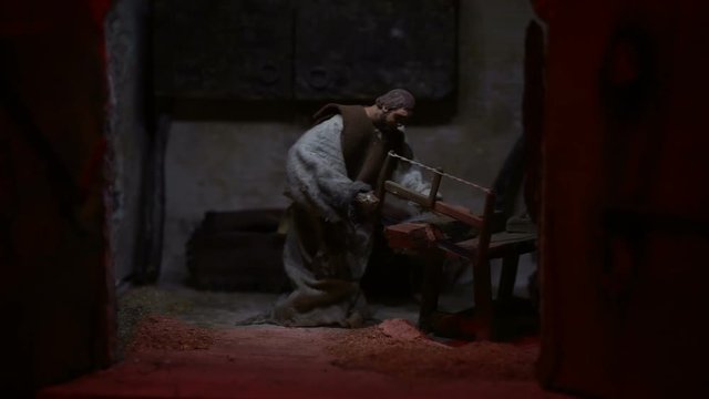 animated statuette of the crib depicting a carpenter with a saw cuts wood
