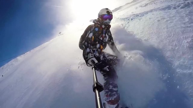 Snowboarding girl in powder in Alps wearing helmet