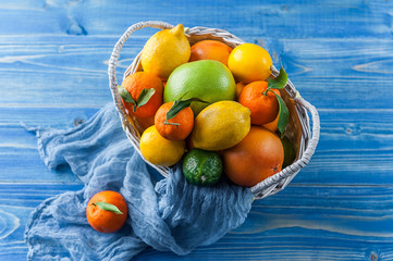 citrus fruits in a wicker basket on a wooden background