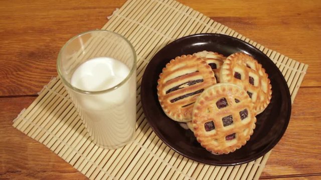 Man breakfast with milk and cookies on the wooden desk