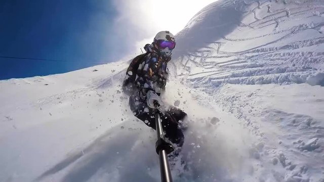 Snowboarding girl in powder in Alps wearing helmet