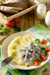 Hot stew meat heart with sour cream and mashed potato side dish.