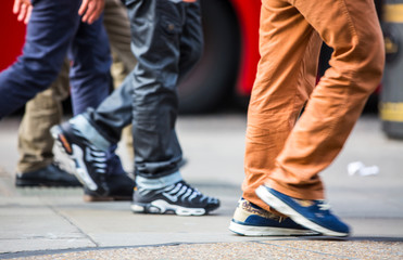 Feet of pedestrians walking on the crosswalk in Oxford street, London. Modern life, travel and shopping concept