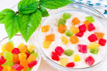 Glass bowl with healthy oatmeal close-up with colorful candied f