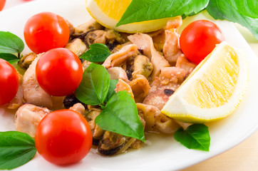 Salad of blanched pieces of seafood on a white plate close-up