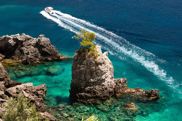 Landscape with azure clear sea with boat and rocks. Paleokastritsa. Near Liapades. Corfu (Kerkyra). Greece