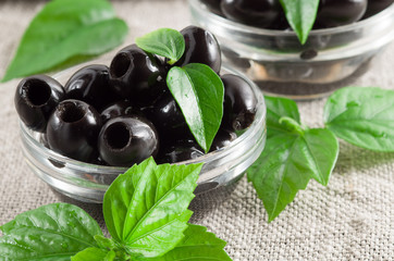 Black olives, pitted marinated in a glass bowl