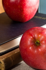 Fragment of old books in hardcover and close-up red apple