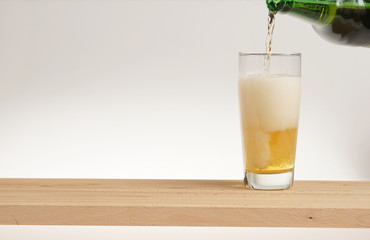 Glass of light beer on a wooden board.