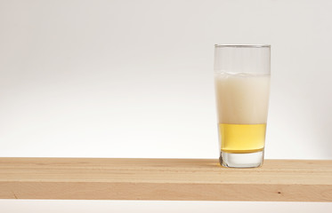 Glass of light beer on a wooden board.