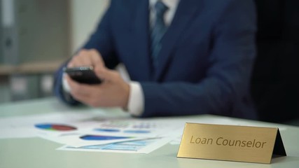 Professional loan counselor using smartphone, resolving clients debt problems